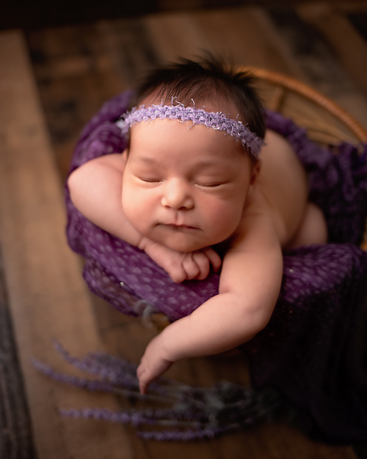 newborn baby girl in basket with purple accessories and lavender newborn photographer minneapolis minnesota