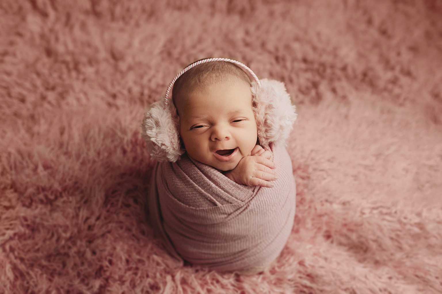 smiling newborn girl in pink pearls and flowers for newborn photography in minneapolis